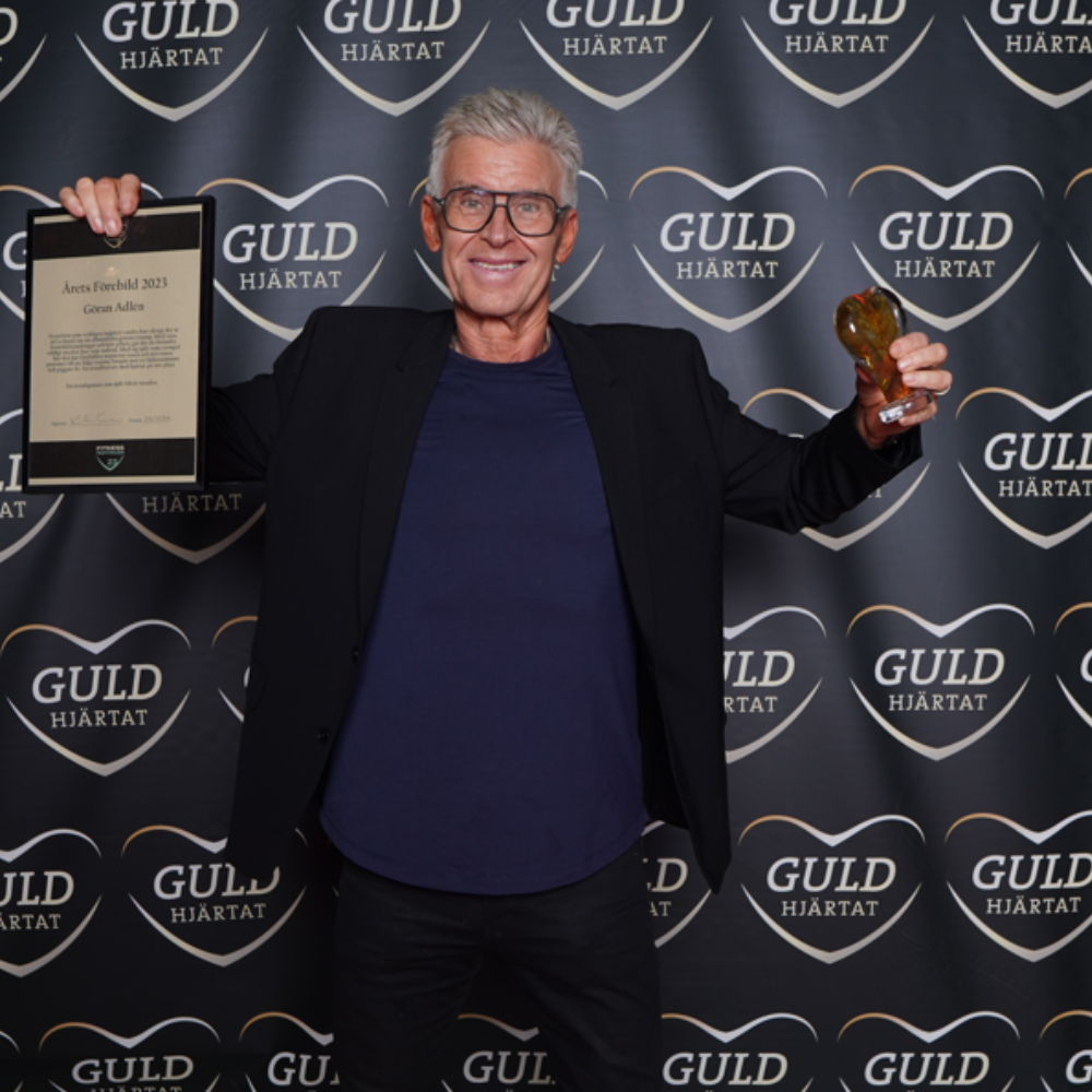 Göran Adlén visar upp sitt guldhjärta och diplom