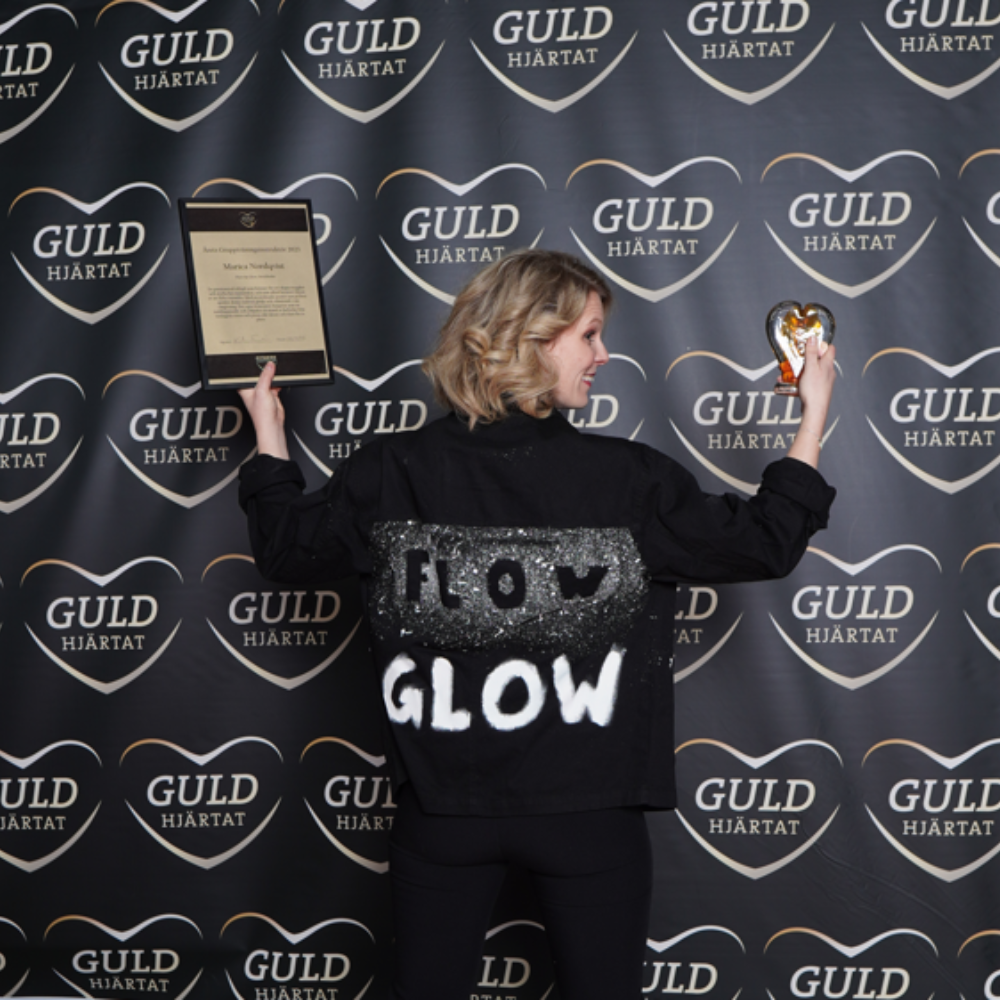 Marica Nordqvist från Flow & Glow visar upp sitt guldhjärta och diplom